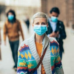 Portrait of young woman on the street wearing face protective mask to prevent Coronavirus and anti-smog