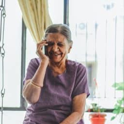 older woman on a cell phone while looking very happy