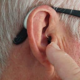 Man points at hearing aid