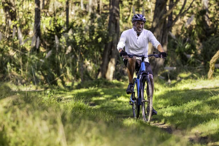Happy man biking on nature trail
