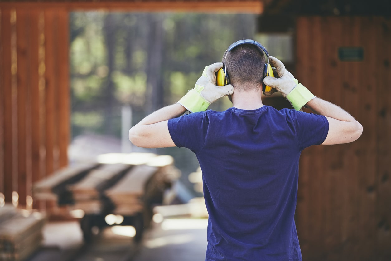 Man wearing ear protection at a loud worksite.