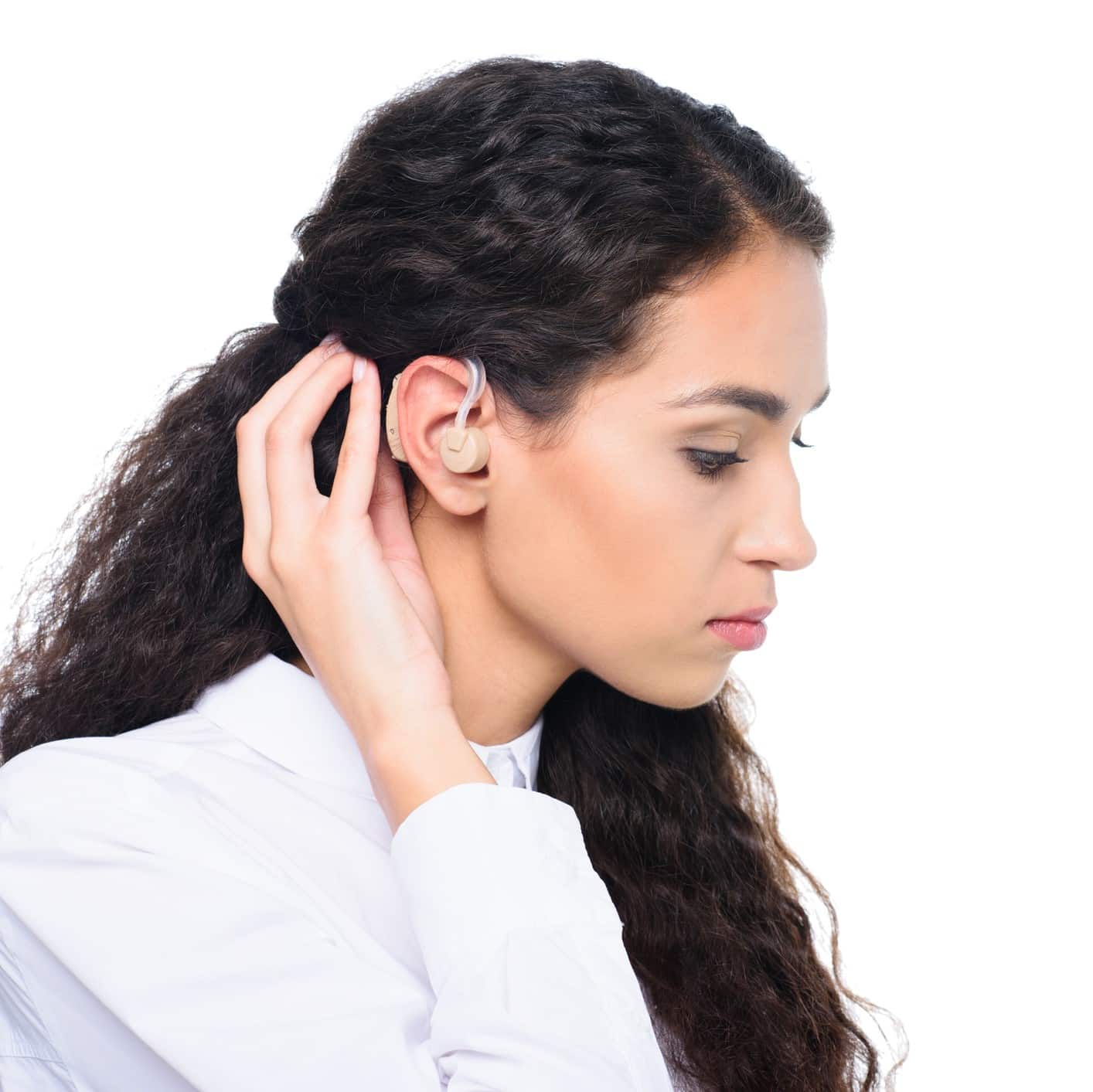 Woman with a hand up to her ear to display her hearing aid